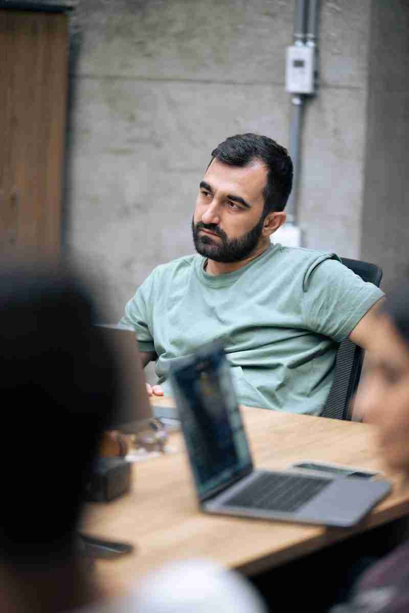 A man sitting at a table with a laptop in front of him